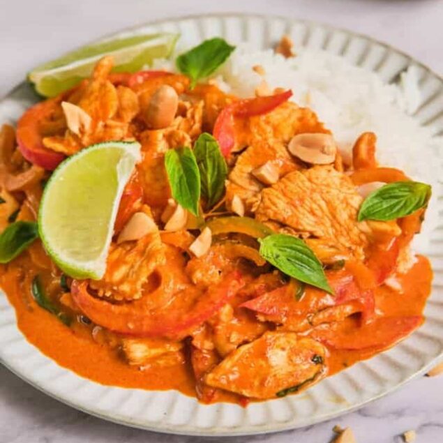 Succulent chicken tikka masala with rice and lime on a white plate, garnished with fresh basil, nuts, and served with rice and lime wedges, emphasizing flavorful Indian-inspired cuisine and healthy meal options, food faith fitness.