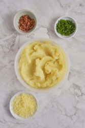 Ingredients for potato balls: mashed potatoes, crumbled bacon, chopped chives, and shredded cheese.