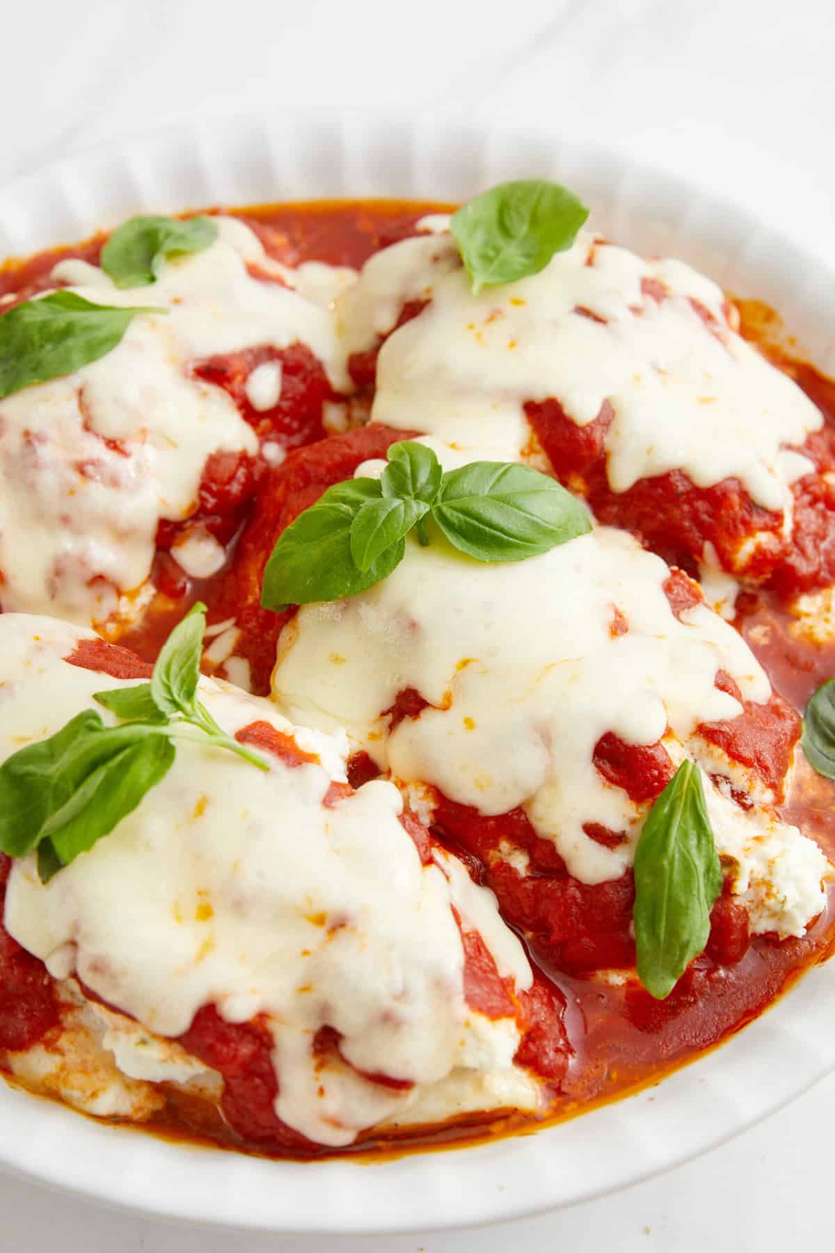 Savory meatballs topped with marinara sauce and melted mozzarella cheese garnished with fresh basil leaves. Healthy, delicious, and easy-to-make Italian comfort food. Perfect for meal prep or family dinner.