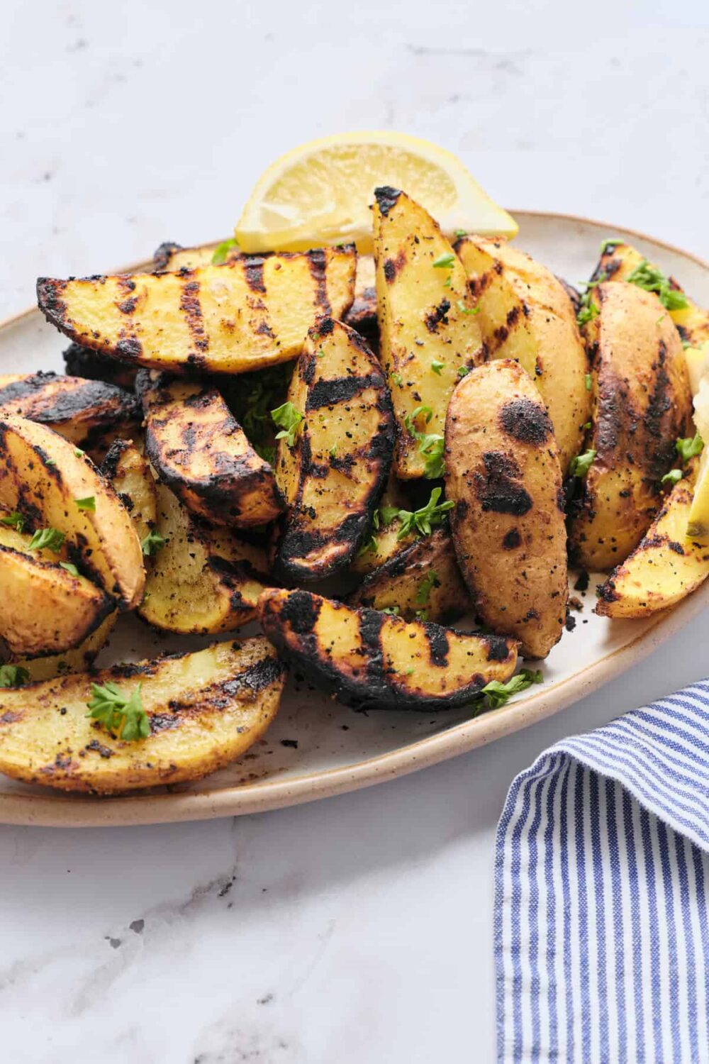 Grilled potato wedges crispy charred with herb seasoning for satisfying BBQ side dish