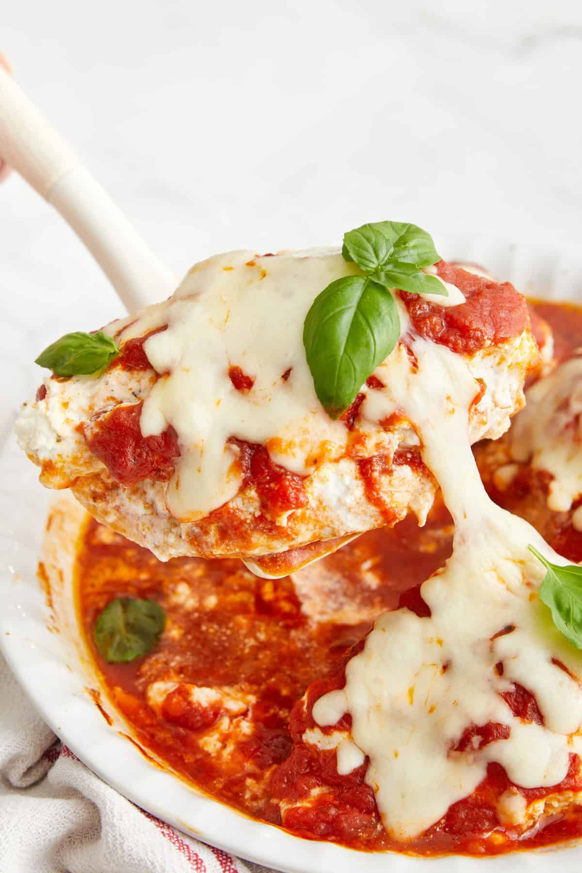 Creamy baked chicken meatballs topped with melted mozzarella cheese and fresh basil, served in rich tomato sauce, perfect for healthy meal ideas.