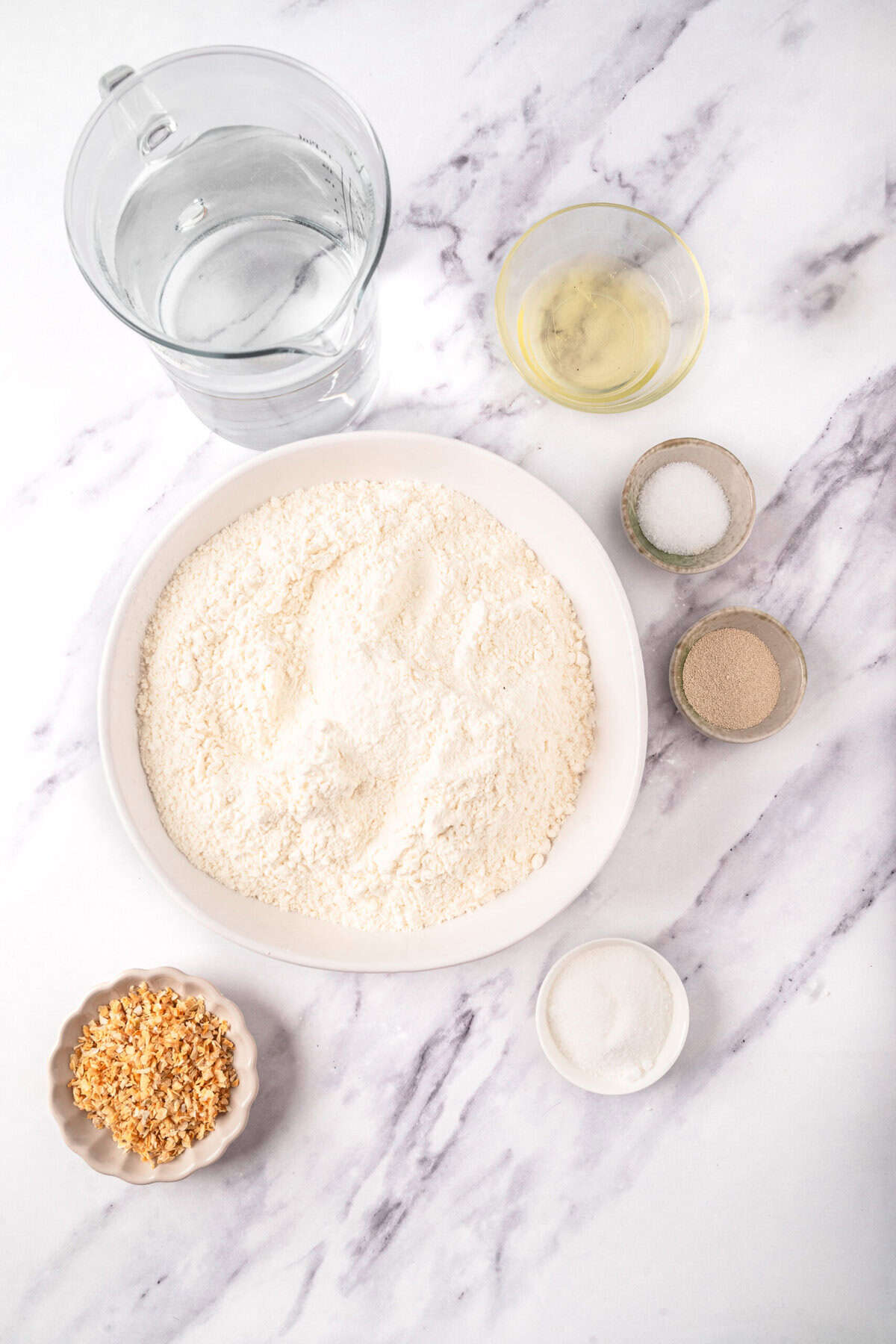 Flour, water, eggs, and seasonings on marble countertop for healthy baking recipe at Food Faith Fitness.