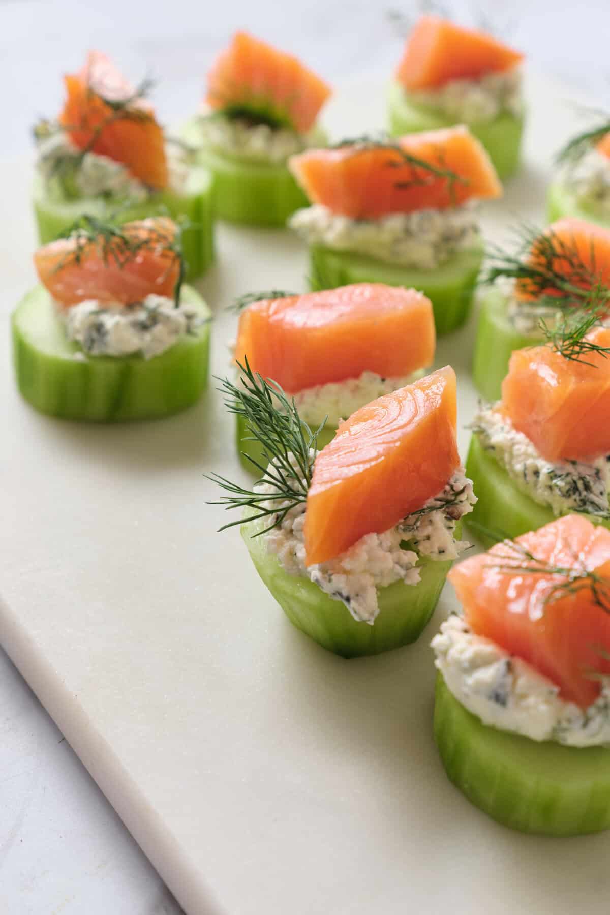 Fresh cucumber bites topped with smoked salmon, creamy herb spread, and garnished with dill, healthy snack ideas for clean eating and nutritious meals.