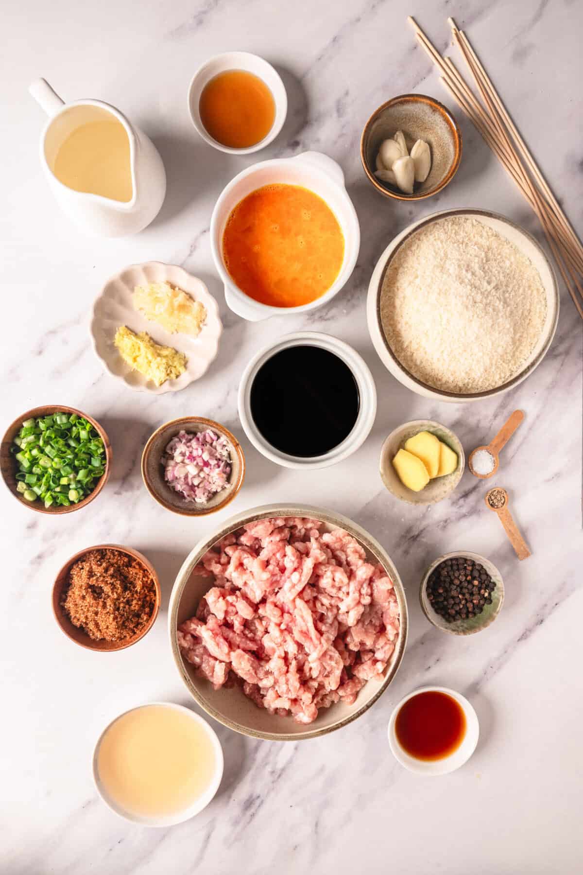 Minced pork, garlic, ginger, soy sauce, rice, and other ingredients arranged on a marble countertop for Asian-inspired cooking, promoting healthy eating and balanced meals from Food Faith Fitness.