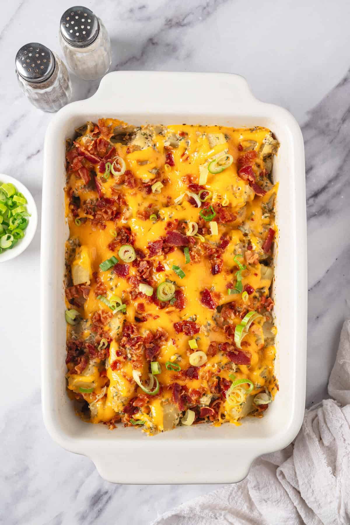 Cheesy baked breakfast casserole with bacon, sausage, and green onions in a white baking dish, healthy breakfast recipes, easy meal prep options, high-protein breakfast ideas, Food Faith Fitness.
