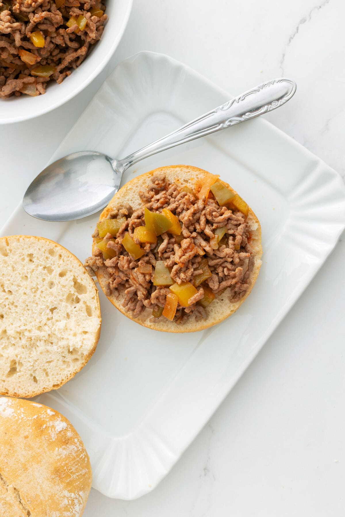Savory ground turkey stuffed bread roll with diced vegetables on a white plate, healthy meal idea, high-protein, meal prep, easy dinner, clean eating, food faith fitness, protein-packed recipes.