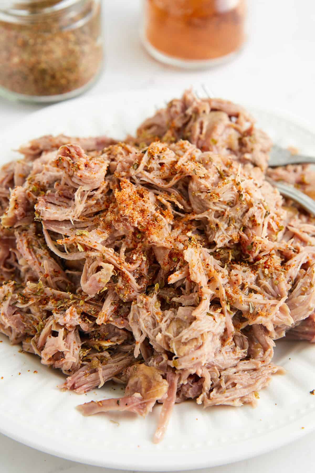 Slow cooker shredded chicken with herbs and spices, perfect for healthy meal prep and versatile recipes.