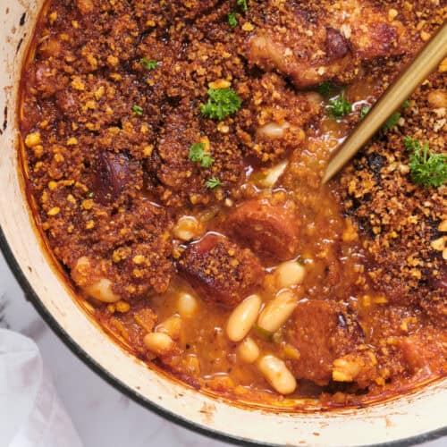 Savory baked chicken casserole topped with crunchy breadcrumb crust, cooked in a tomato-based sauce with beans, garnished with fresh herbs. Perfect comfort food recipe for healthy eating.