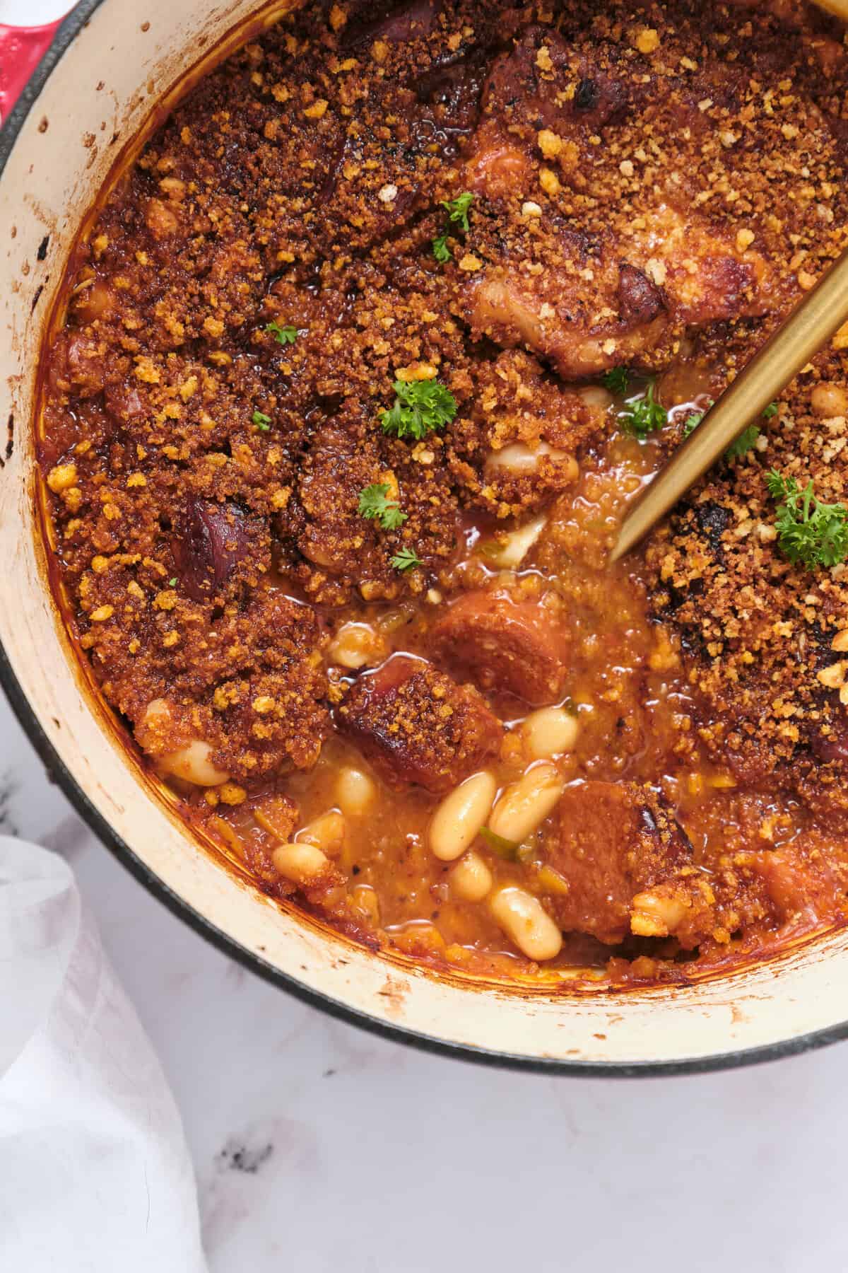 Savory baked chicken casserole topped with crunchy breadcrumb crust, cooked in a tomato-based sauce with beans, garnished with fresh herbs. Perfect comfort food recipe for healthy eating.