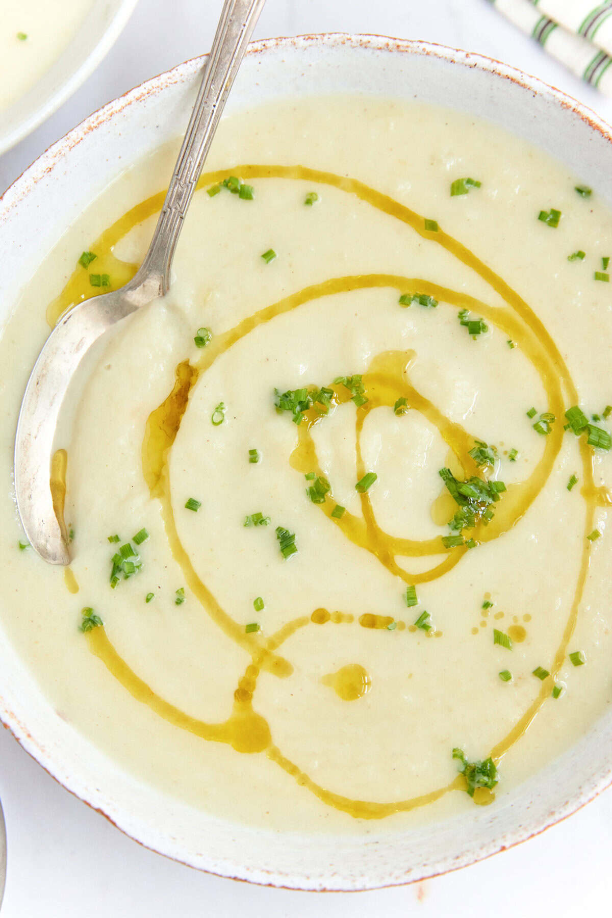 Creamy potato leek soup garnished with fresh chives and a drizzle of olive oil, perfect for healthy eating and meal prep.