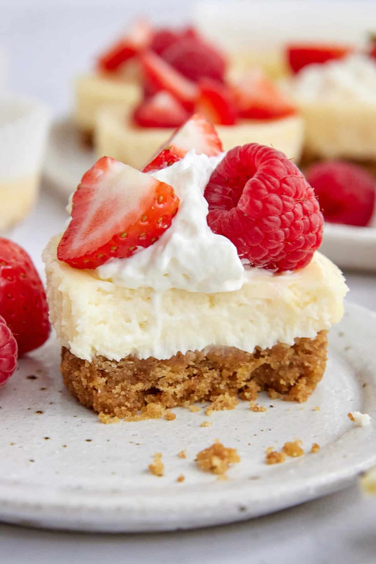 Butterscotch Berry Cheesecake Bars topped with fresh strawberries, raspberries, and whipped cream, perfect for healthy dessert options and fruit-loving recipes.