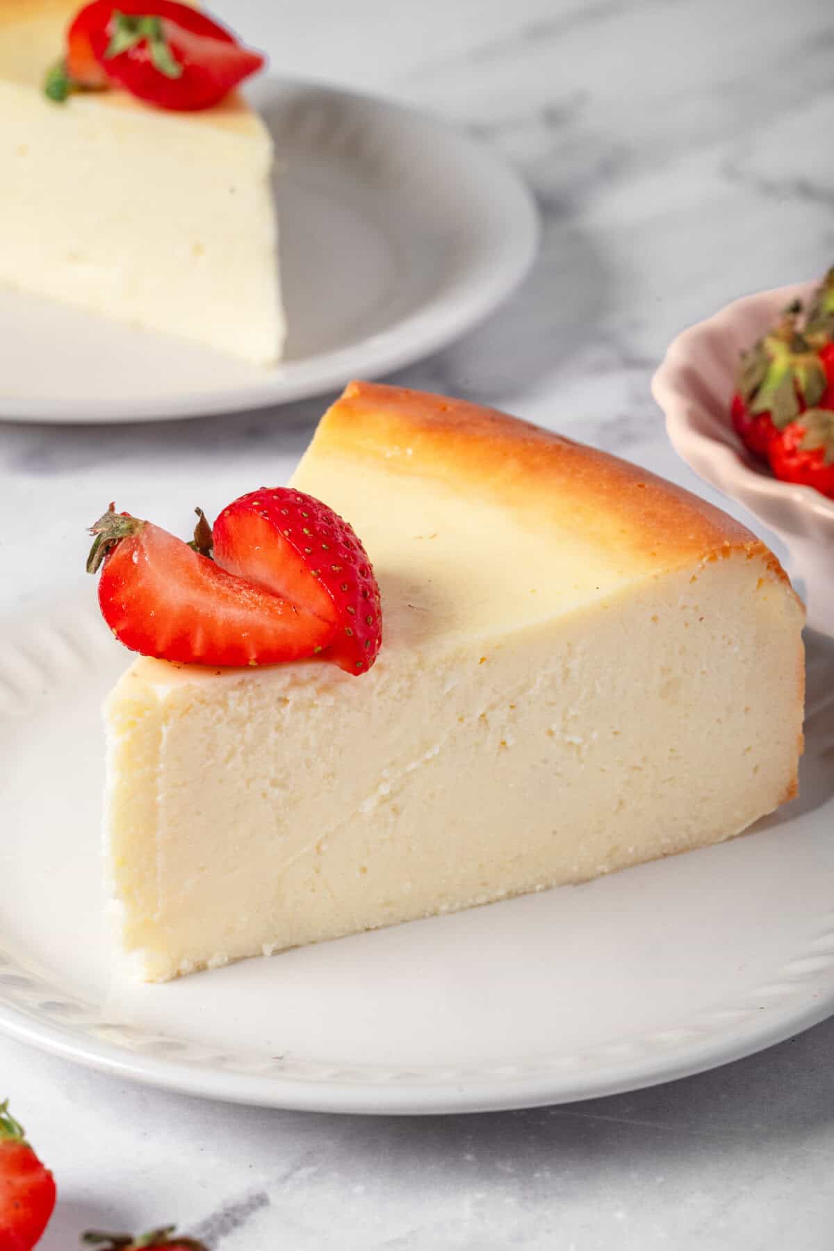 Creamy New York style cheesecake topped with fresh strawberries, perfect for a healthy dessert or snack. Made with simple ingredients, it's delicious and vegetarian-friendly.
