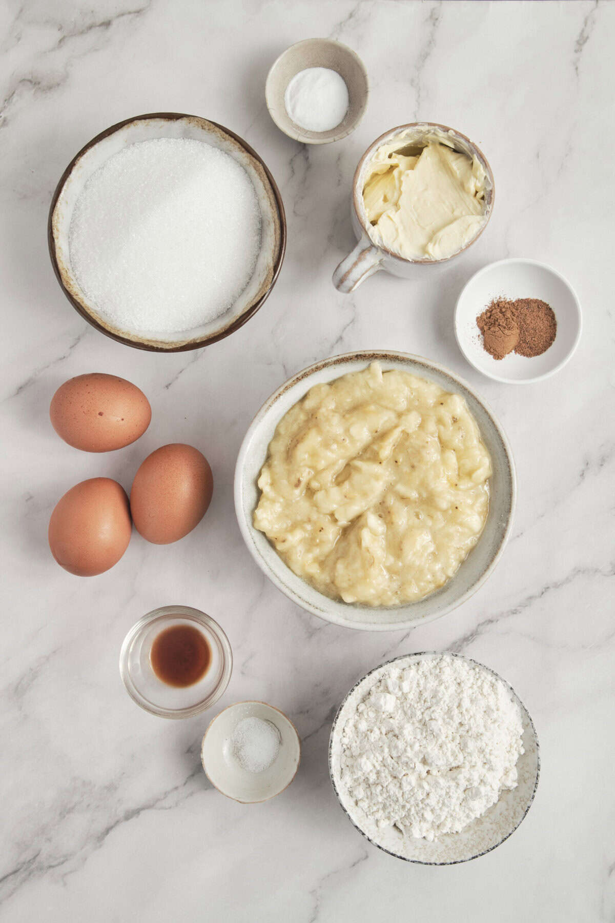 Eggs, flour, sugar, butter, vanilla, ingredients of baking on a marble surface for home recipe for baking.