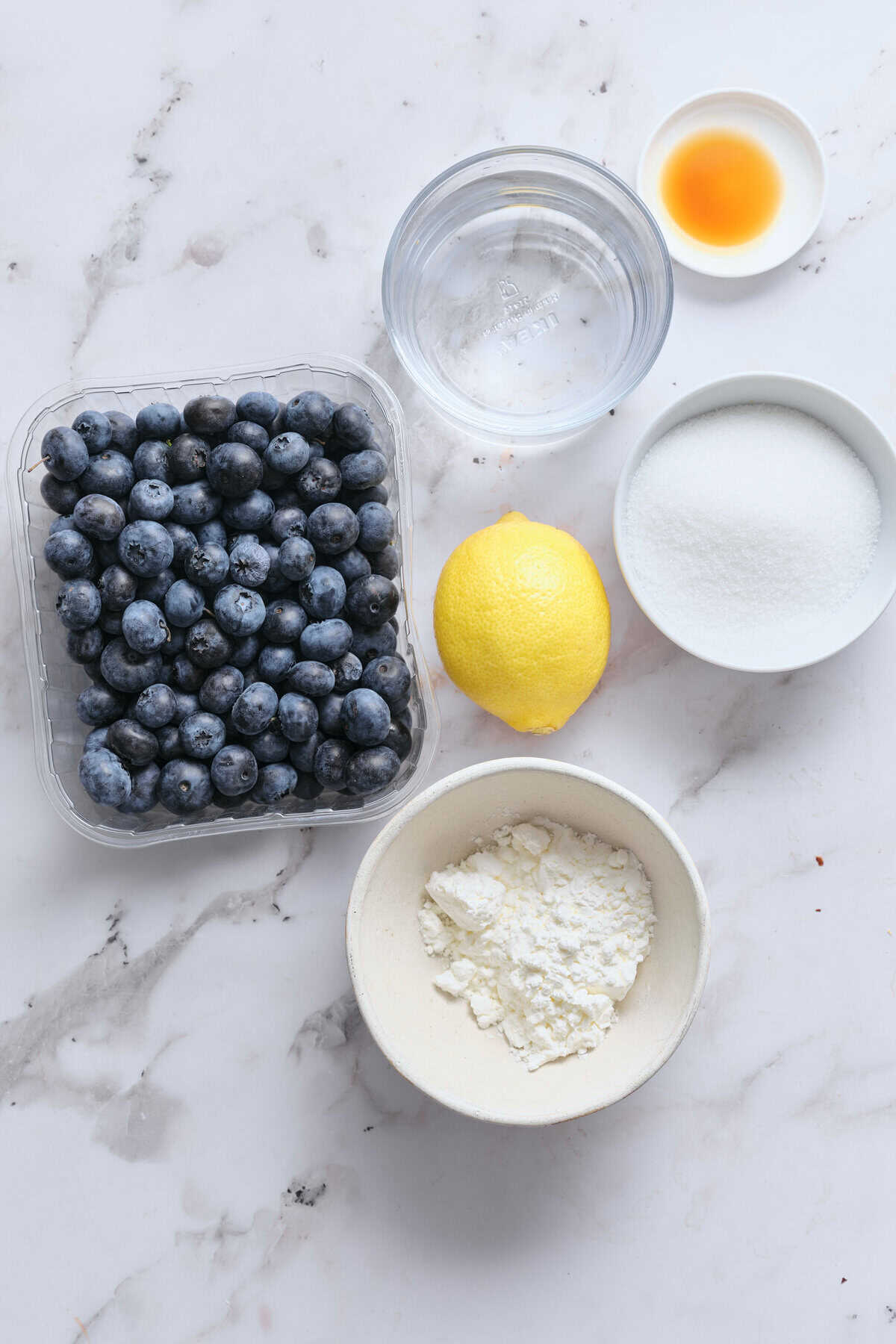 Fresh blueberries, lemon, vanilla extract, sugar, and ricotta cheese ingredients for healthy dessert recipes or smoothies. Simple, nutritious, and perfect for a balanced diet.