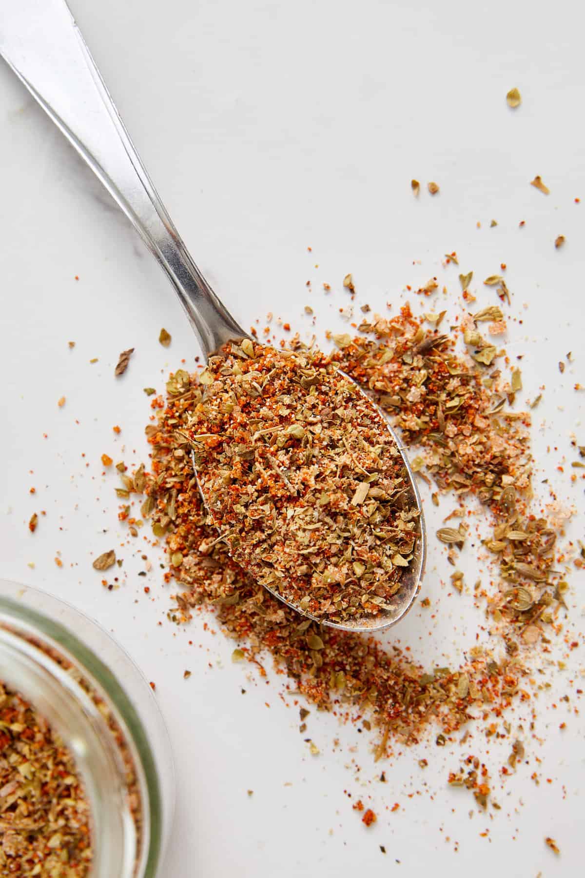 Blend of nutritional herbs and spices in a spoon on a white background for healthy eating and wellness.