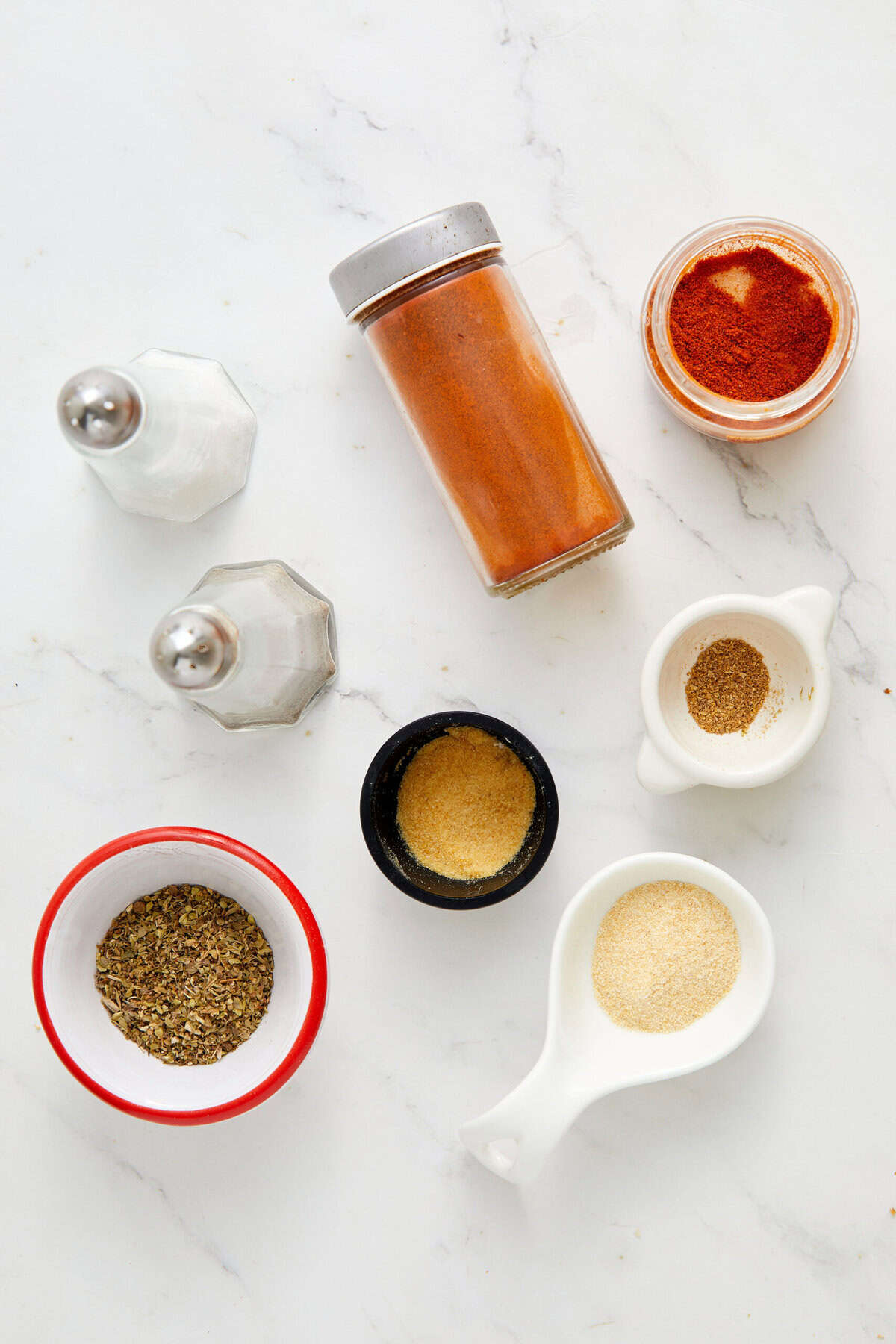 Ground spices and seasonings for healthy cooking and recipes on a white marble surface.