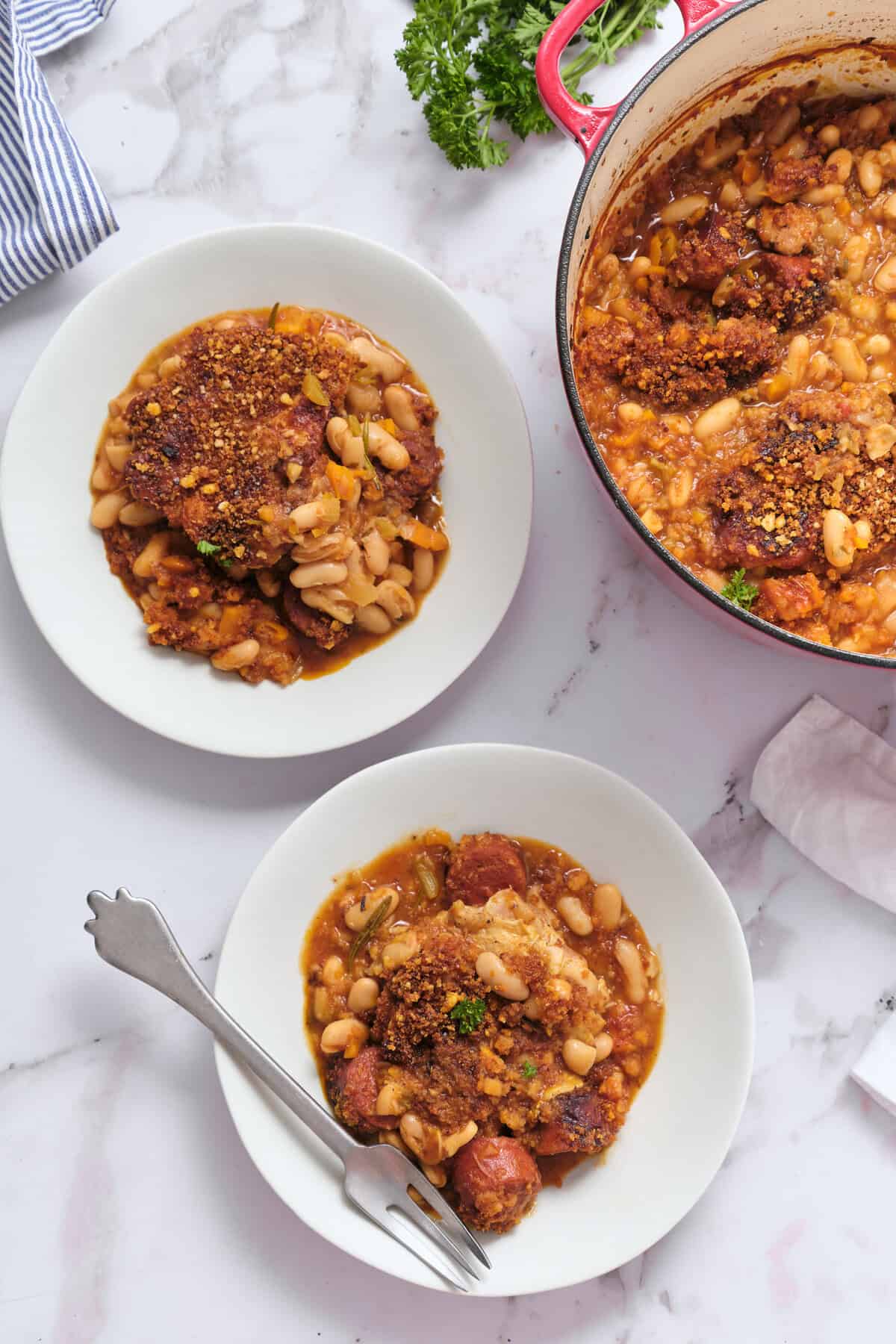 Oven-baked turkey meatloaf with white beans and tomato-based sauce served on white plates.