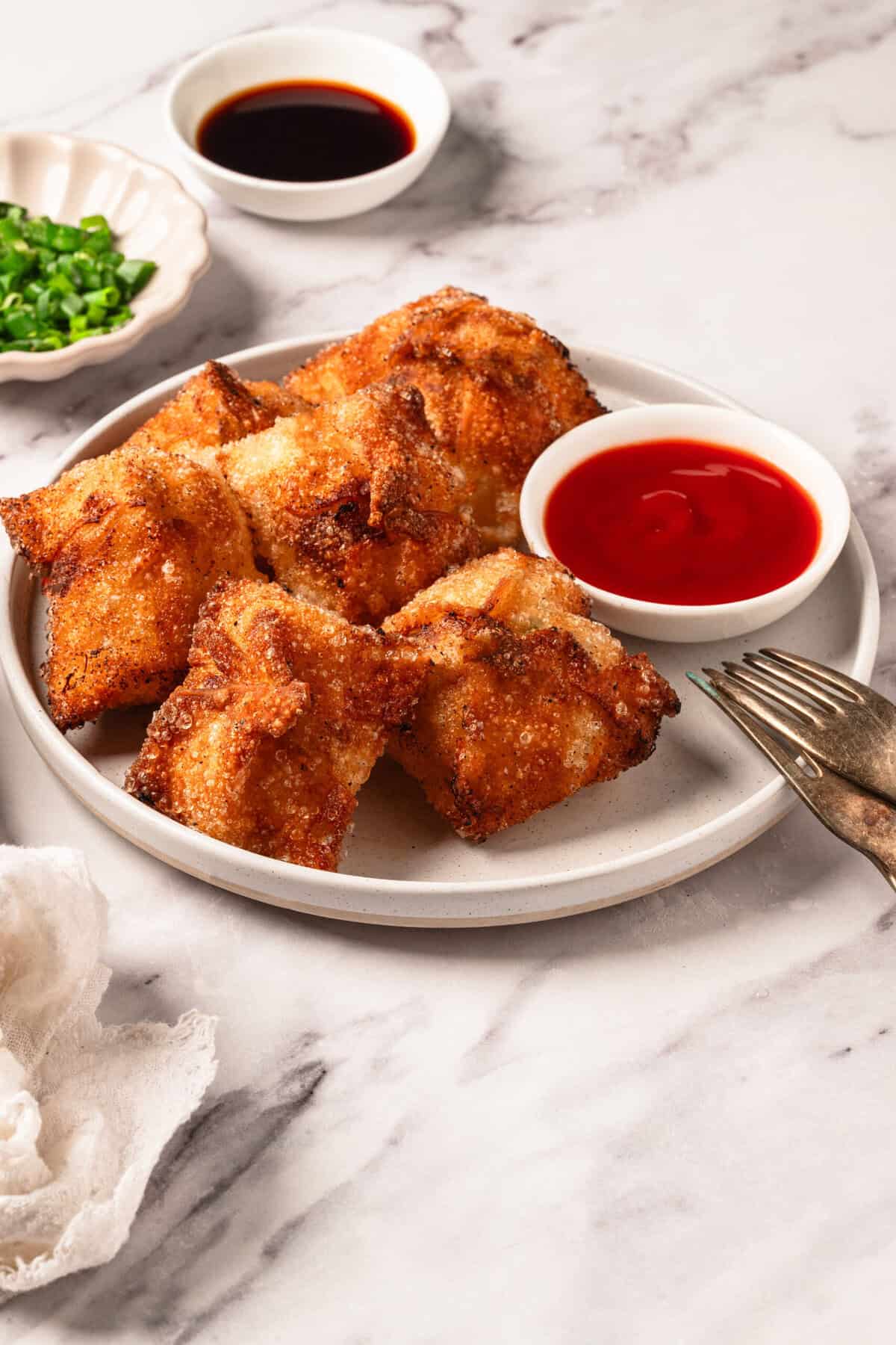 Crispy baked chicken drumsticks with sweet chili sauce on a white plate, served with green onion garnish and soy sauce, emphasizing healthy and flavorful meal options from Food Faith Fitness.