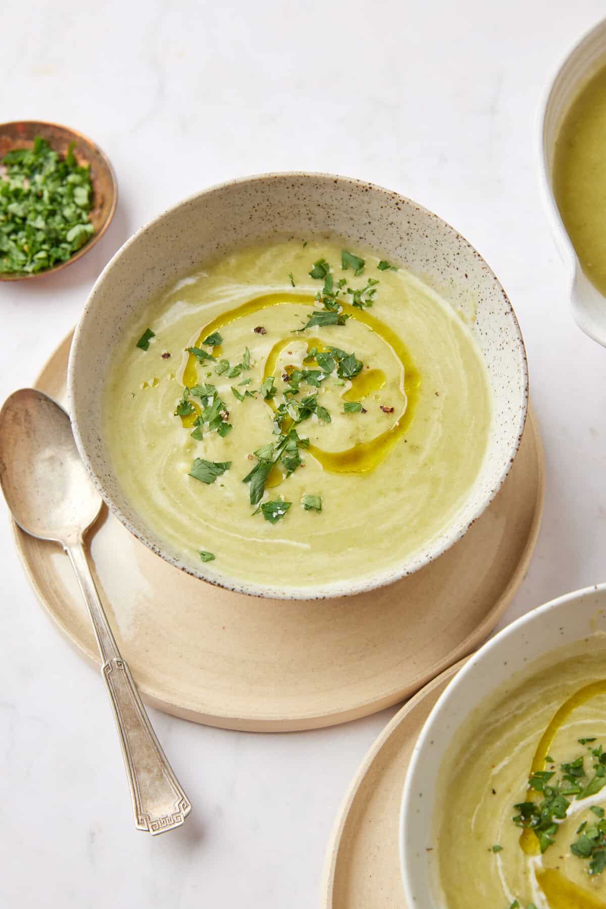 Creamy green vegetable soup garnished with fresh herbs and olive oil, perfect for healthy eating and nutritious meal ideas.