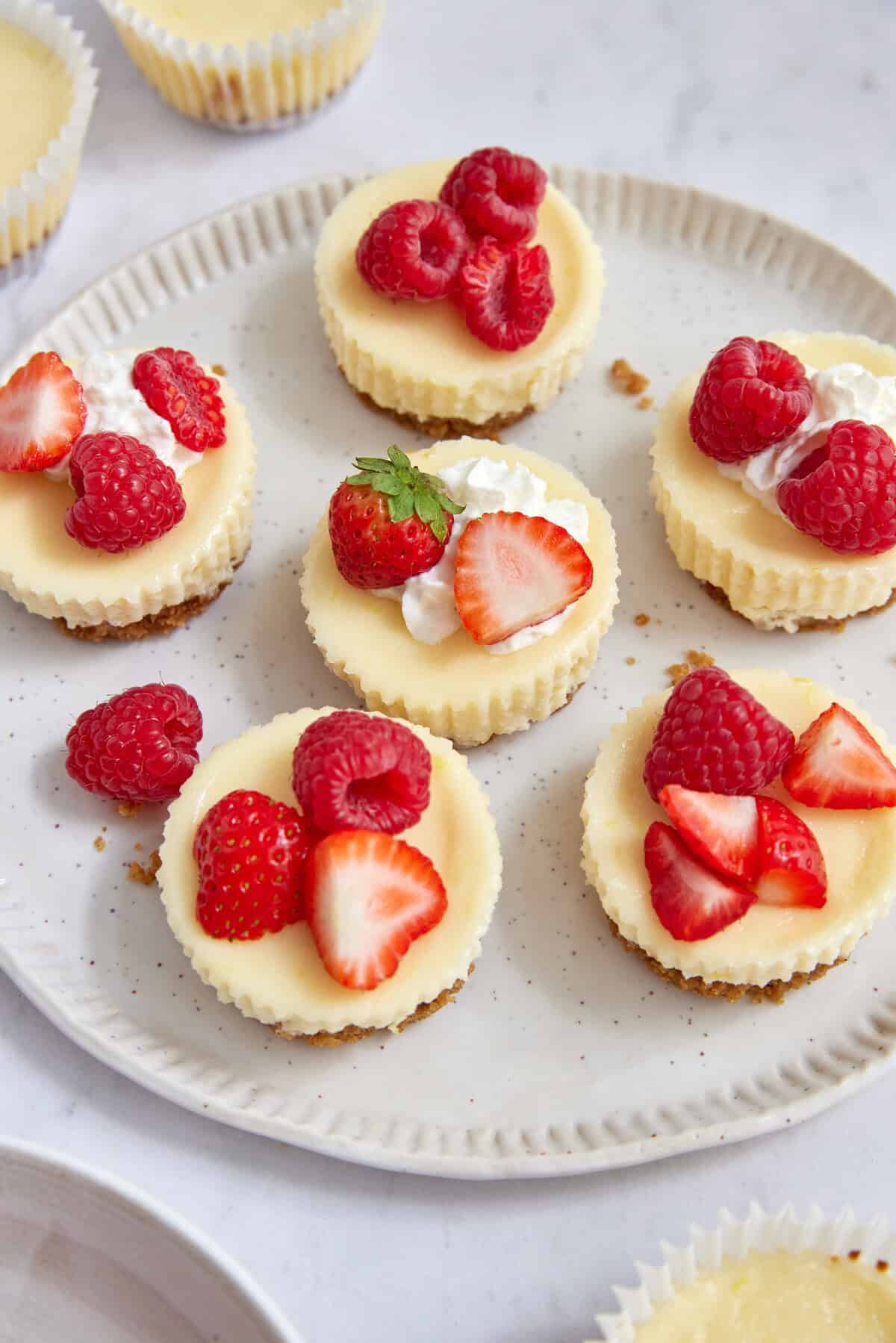 Delicious cheesecake bites topped with fresh strawberries, raspberries, and whipped cream, perfect for healthy dessert options and balanced eating.