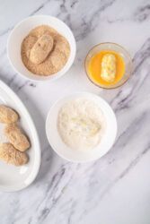Coating potato croquettes in flour, egg wash, and breadcrumbs.