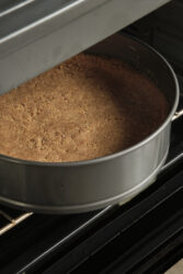 Strawberry cheesecake crust baking in a springform pan.