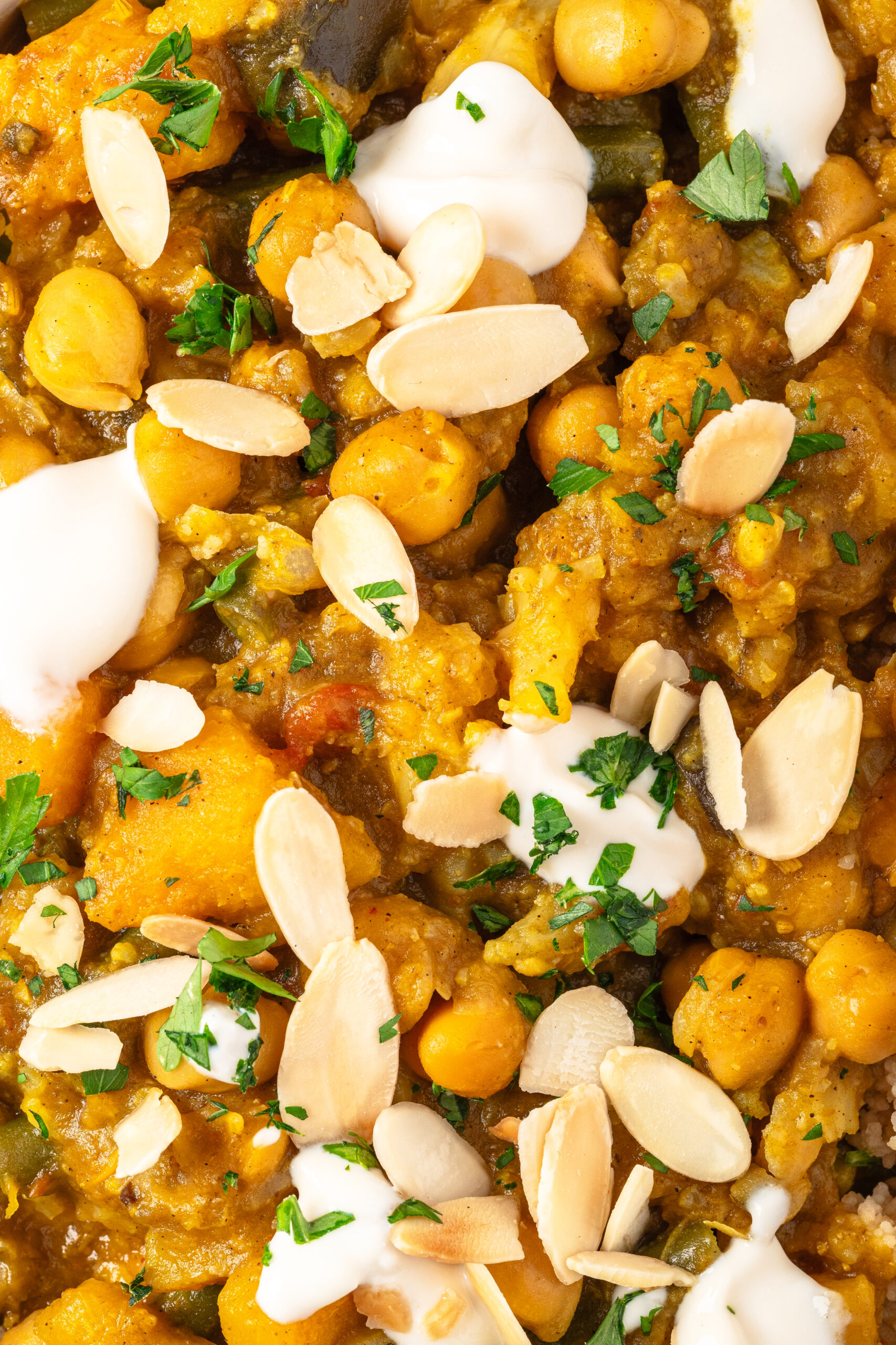 Creamy chickpea and vegetable curry with almonds, fresh herbs, and yogurt garnish - healthy vegan recipe from Food Faith Fitness.