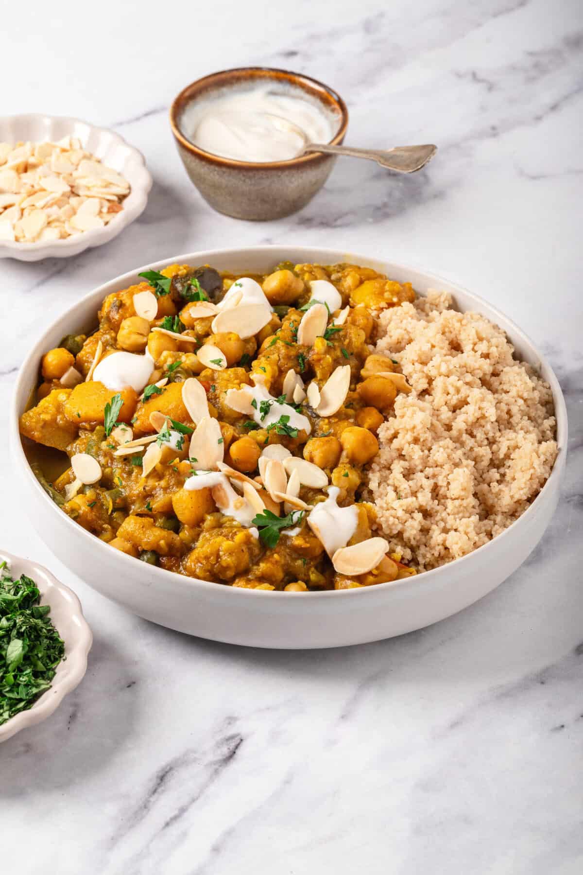 Savory chickpea and sweet potato curry served with cauliflower rice, topped with sliced almonds and fresh herbs, perfect for healthy meal prep and balanced nutrition.