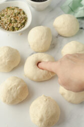 Poking a hole in sourdough bagel dough.