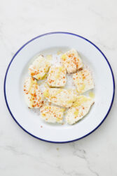 Air-fryer halloumi cheese slices with olive oil and paprika.