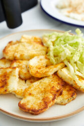 Air-fryer halloumi cheese served on a plate with shredded greens.