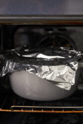 Baking chicken scarpariello in a foil-covered Dutch oven.
