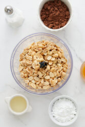 Placing peanuts in a food processor for homemade chocolate peanut butter.