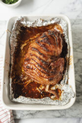 Glazed honey-baked ham in a baking dish, fresh from the oven.