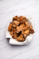 Golden brown karaage chicken pieces resting on paper towels.