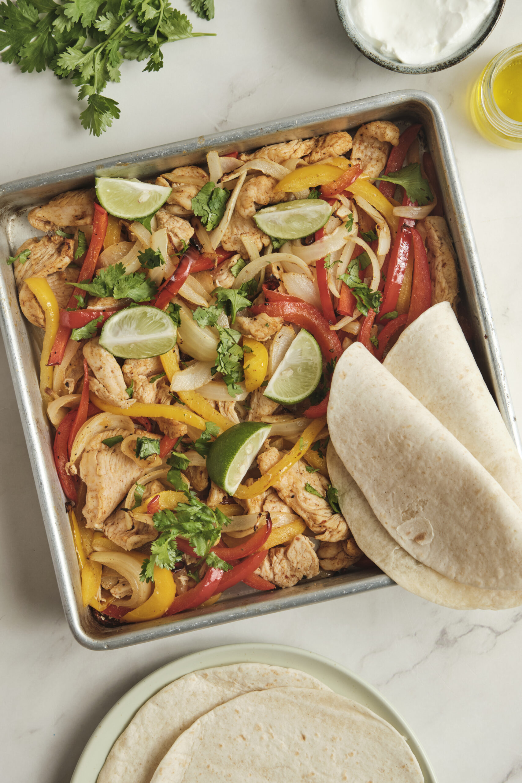 Sheet pan fajitas in baking tray shot from above.