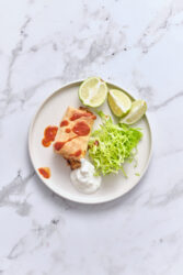 Chimichanga with salsa, sour cream, shredded lettuce, and lime.