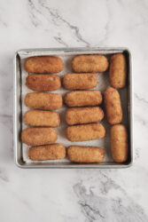 Golden brown ham croquettes draining on paper towels.