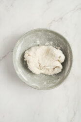 Dough for pork buns in a grey bowl.