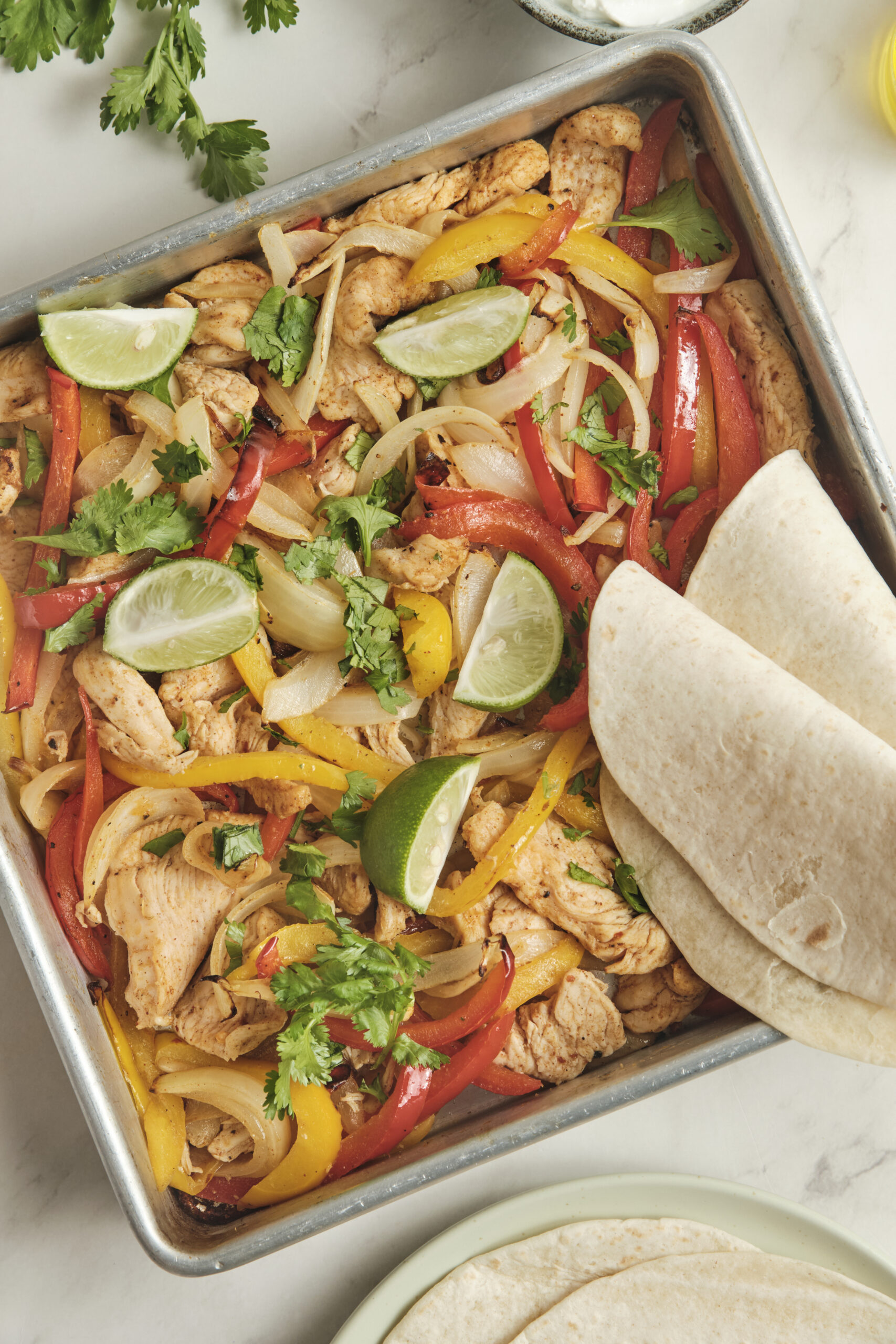 Sheet pan fajitas in baking tray shot from above.