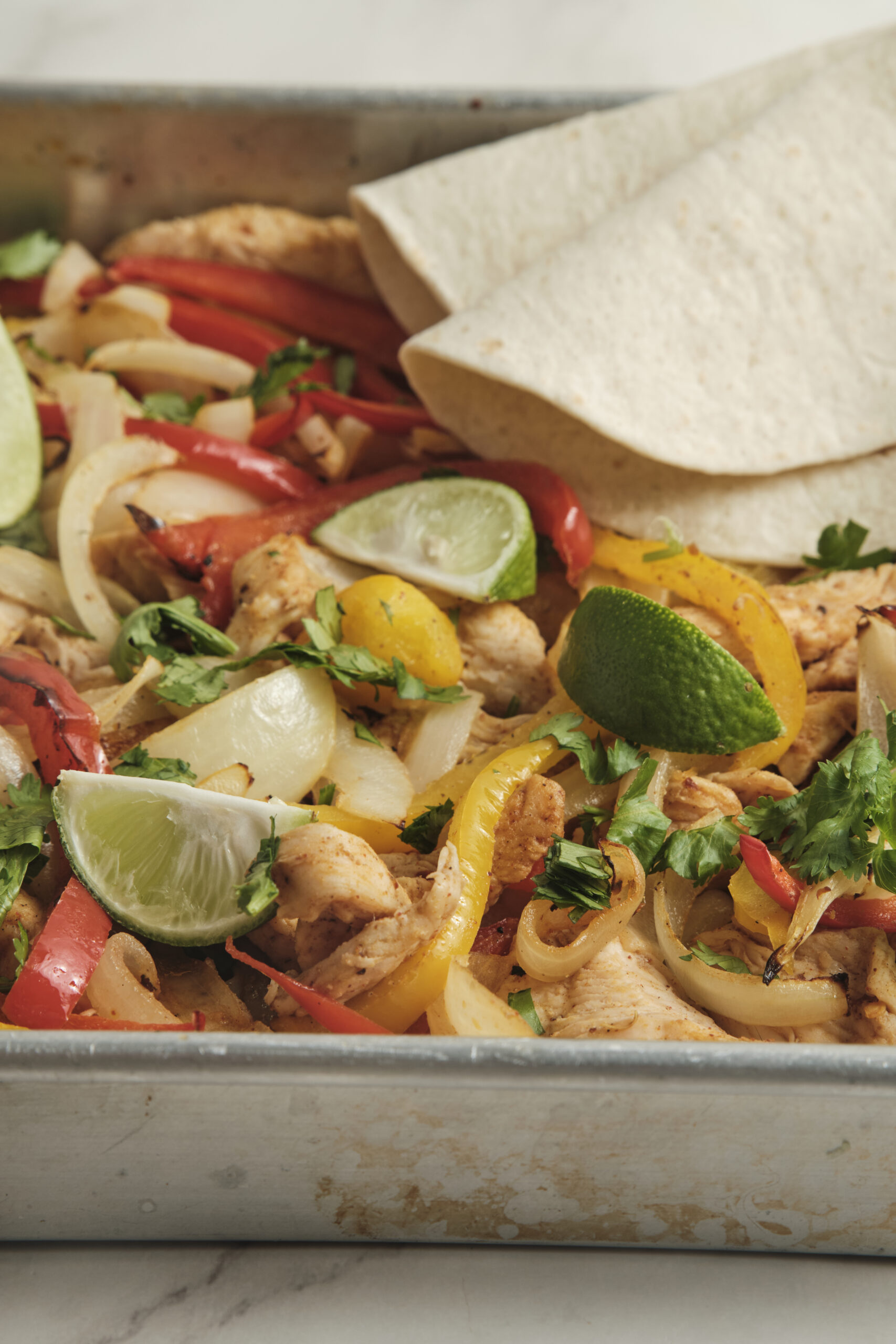 Sheet pan fajitas in baking trai closeup shot.