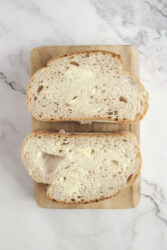 Two buttered bread slices for a tuna melt recipe.