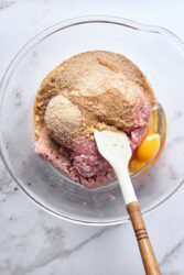 Combining ground ham, pork, crumbs, and eggs for ham balls.