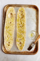 Brushing olive oil on sliced bread for pizza bread.