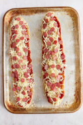 Pizza bread halves topped with sauce, cheese, and mini pepperoni.